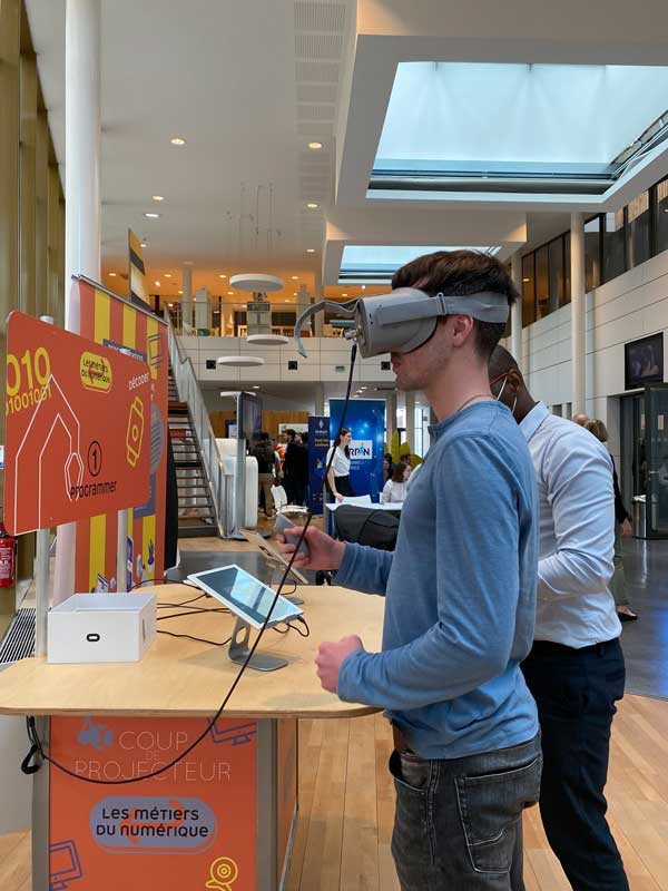Un jeune homme utilise un casque de réalité virtuelle pour explorer les métiers du numérique lors d’un événement organisé par Cap Métiers Nouvelle-Aquitaine.
