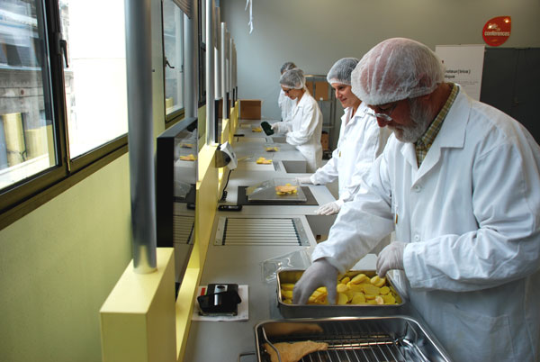 Participants en blouse et charlotte réalisant une simulation de conditionnement de produits alimentaires lors de l’exposition « Transformation » de Cap Métiers Nouvelle-Aquitaine.